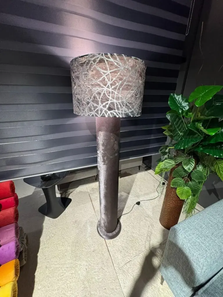 Lampada da terra tortora con paralume ricamato, esposta in showroom