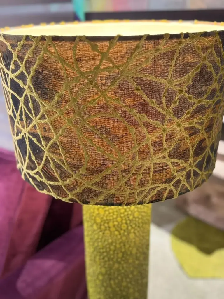 Lampada da terra verde con paralume ricamato, esposta in showroom
