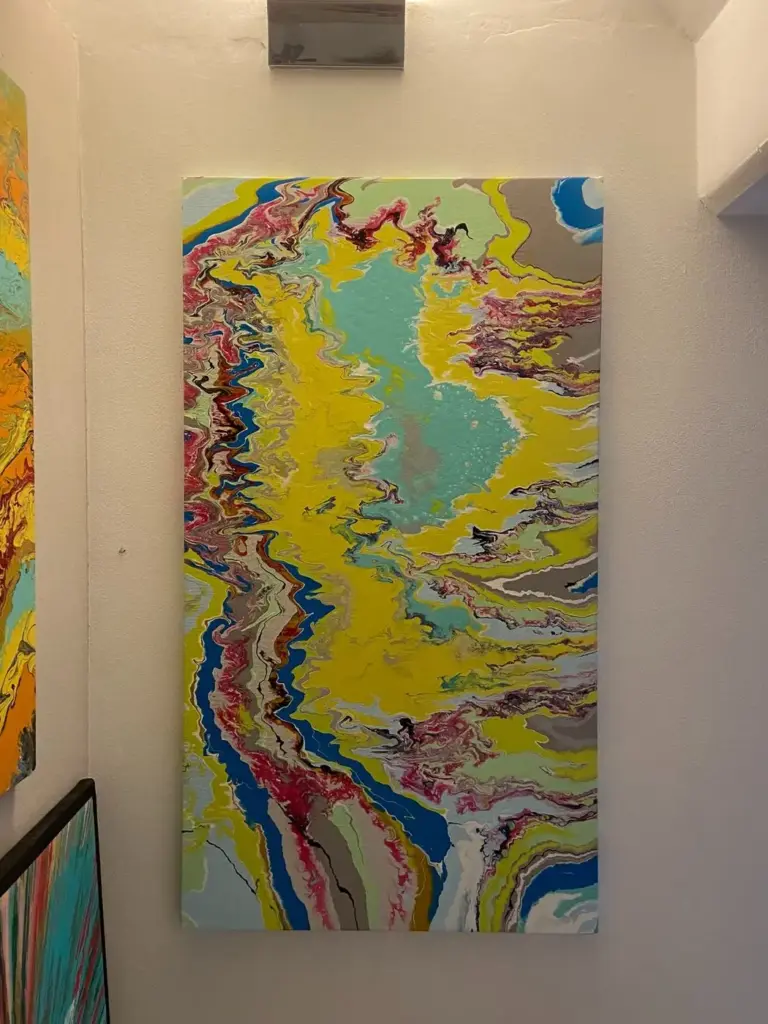 Quadro astratto giallo e turchese esposto nello showroom Confort Salotti