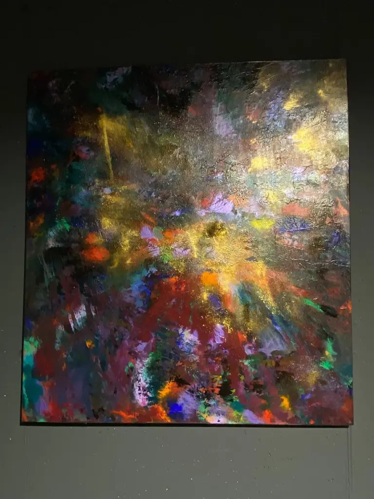 Quadro astratto scuro con luce dorata esposto nello showroom Confort Salotti