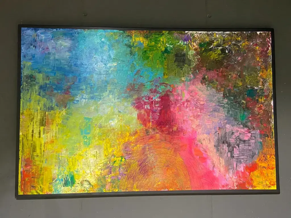 Quadro astratto azzurro, giallo e rosa a spatola esposto nello showroom Confort Salotti