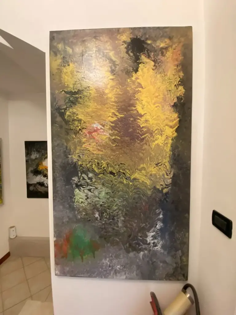 Quadro astratto verticale grigio e oro esposto nello showroom Confort Salotti